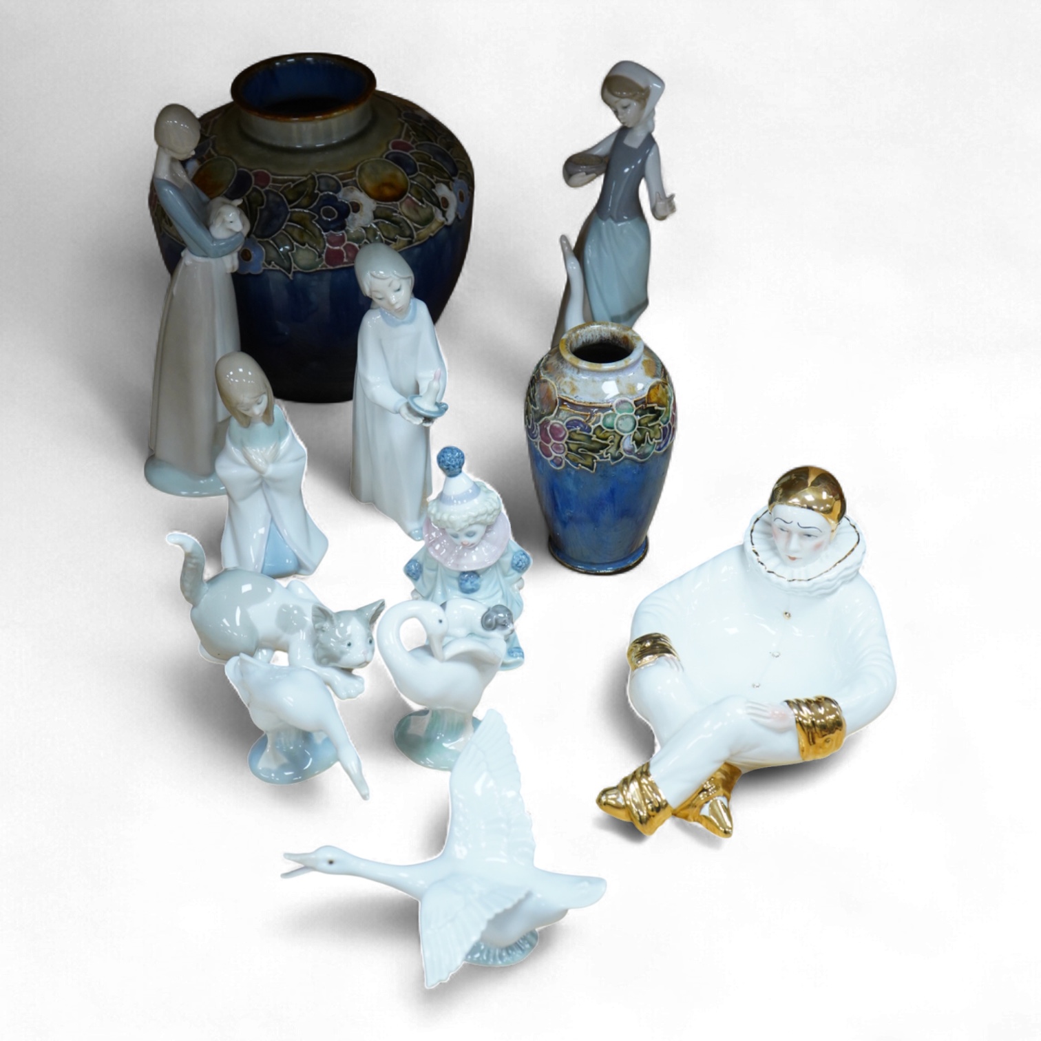 Two Doulton vases, a Casa Pupo pierrot dish and a collection of nine Lladro figures, largest 27cm high